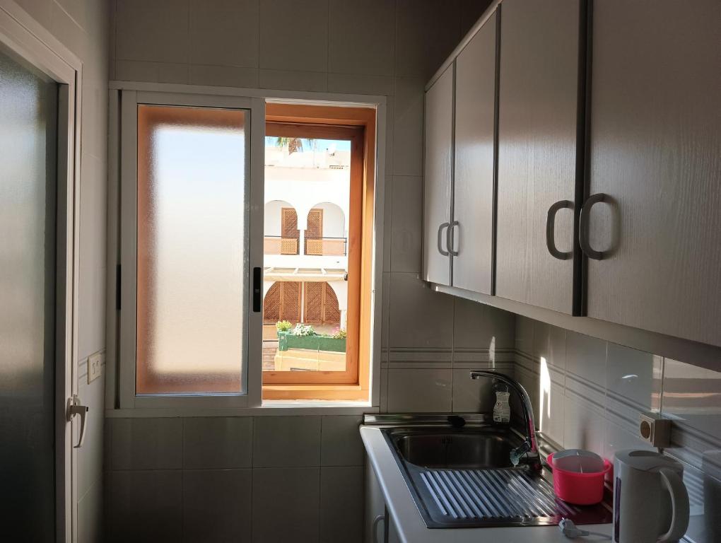eine Küche mit einem Waschbecken und einem Fenster in der Unterkunft Apartamento en Puerto de Mazarrón in Puerto de Mazarrón