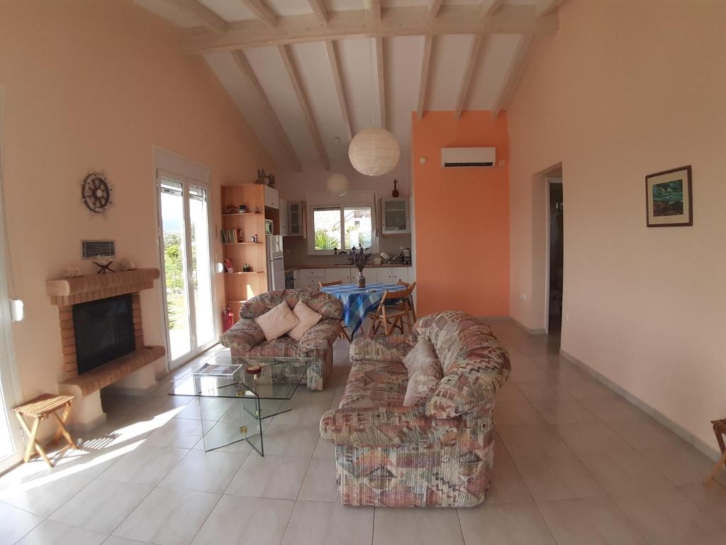 een woonkamer met 2 banken en een open haard bij Panorama View Evia GREECE in Kamarítsa