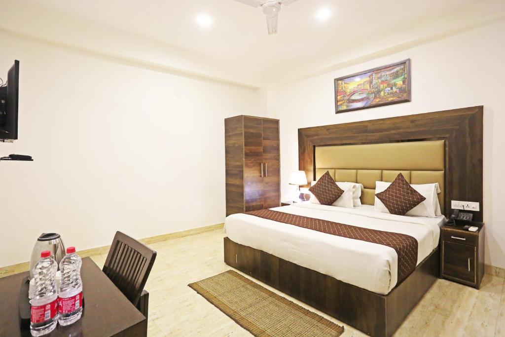 a bedroom with a large bed and a desk with a desk at Hotel De Kiara Near Delhi Airport in New Delhi