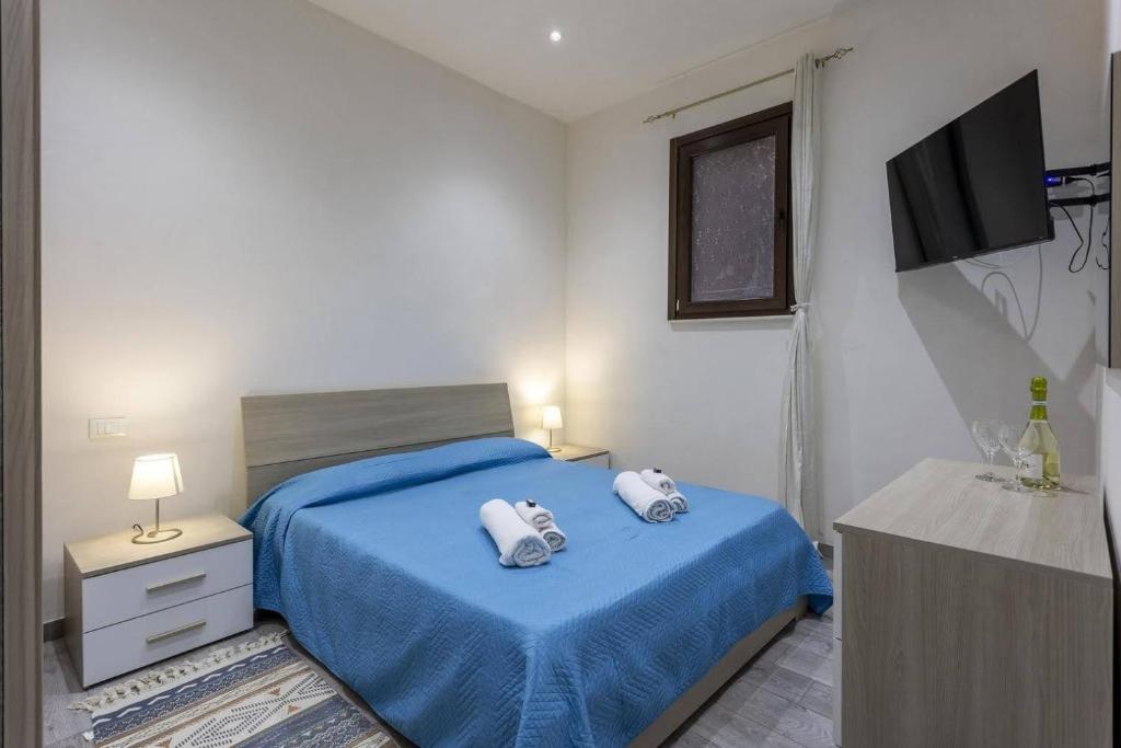 ein Schlafzimmer mit einem blauen Bett und Handtüchern darauf in der Unterkunft Tampasio Apartment Trapani centro in Trapani