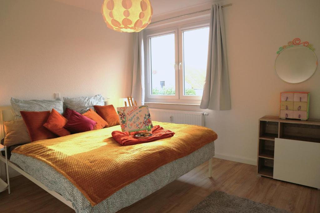 1 dormitorio con cama, ventana y espejo en Ferienwohnung #ComicLoft in Gehrden - Wlan - Küche - zentral aber ruhig, en Gehrden