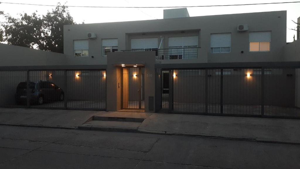 ein Haus mit einem Zaun und einer Tür mit Licht in der Unterkunft LA ESTACION in Gualeguaychú