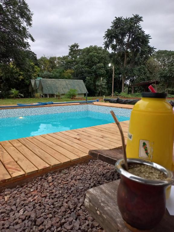 uma piscina com um deque de madeira e uma garrafa térmica amarela em Del monte Dormis em Dos de Mayo