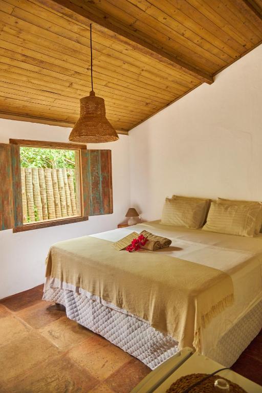 a bedroom with a large bed with a window at Casa Baleia - Caraíva - 100m da Igreja in Caraíva
