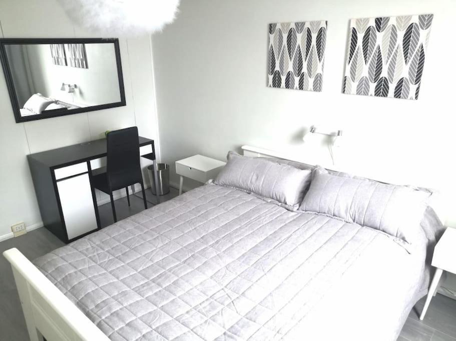 コウヴォラにあるValoisa & tilava 3.krs kaksio, lasitettu parvekeのベッドと机と鏡のある寝室