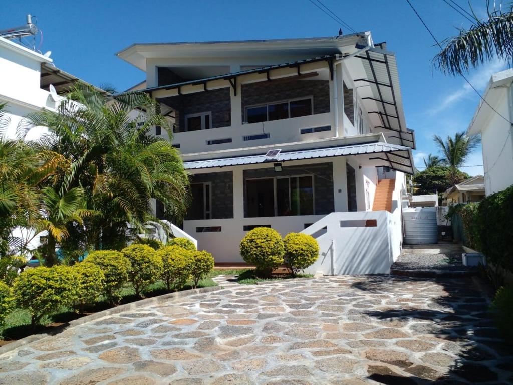 une maison avec une passerelle en pierre devant elle dans l'établissement Real Mauritius Apartments, à Grand Gaube