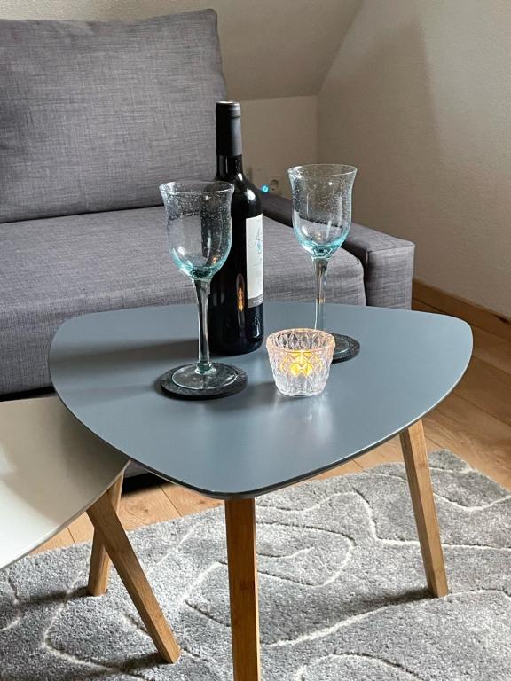 a table with two glasses and a bottle of wine at Haus am gelben Berg in Dittenheim