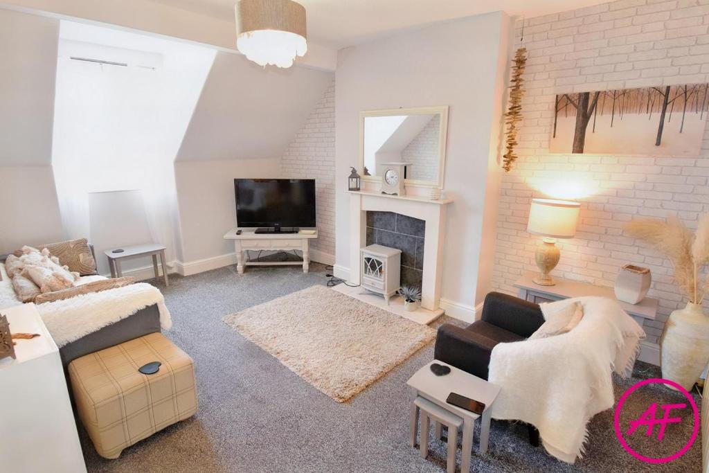 a living room with a couch and a tv at Willesden, Flat 2, A 1 Bedroom flat right in the heart of Llandudno in Llandudno