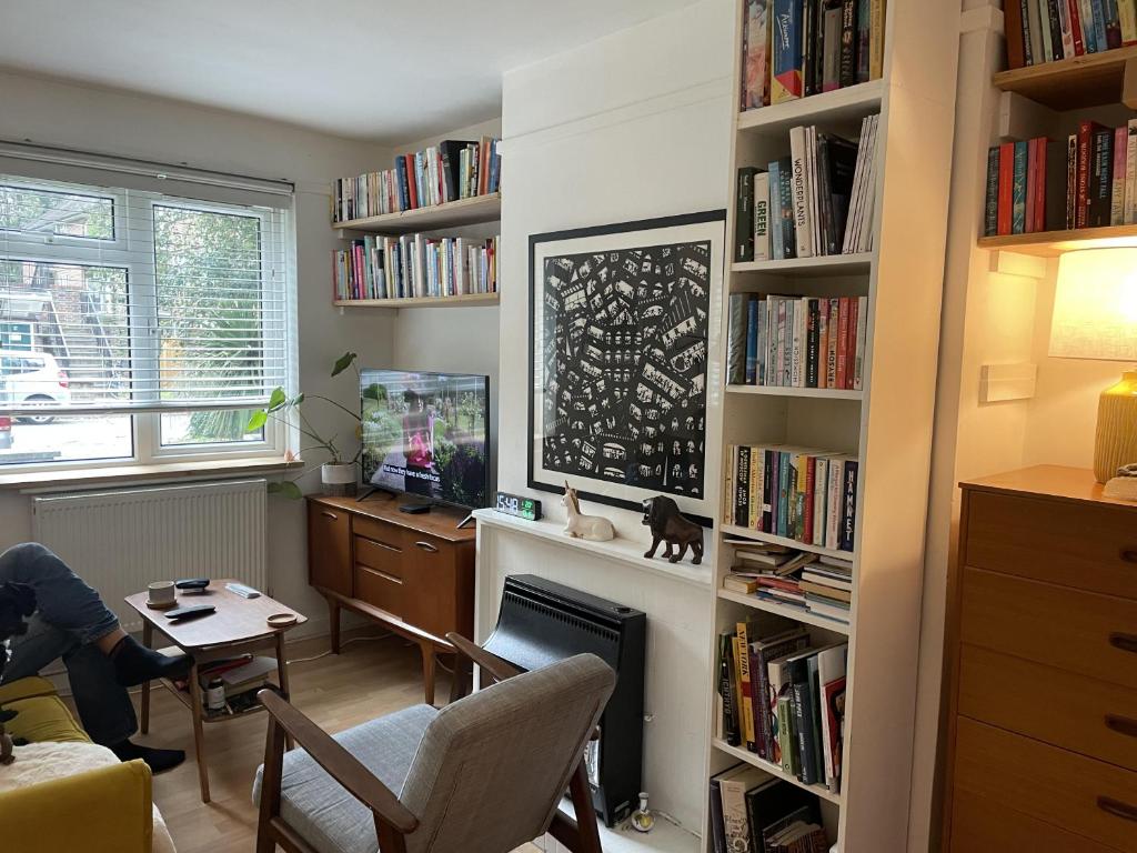 a living room with a desk and bookshelves at Charming studio Apartment in London in London