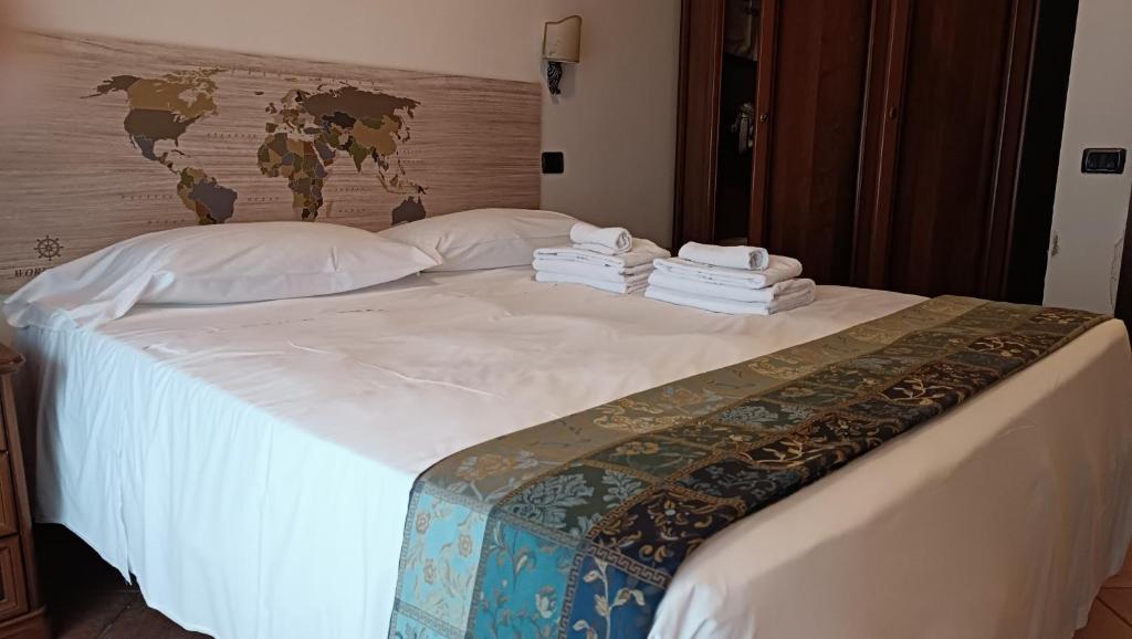 a bed with white sheets and towels on it at EURO HOUSE INN airport in Fiumicino