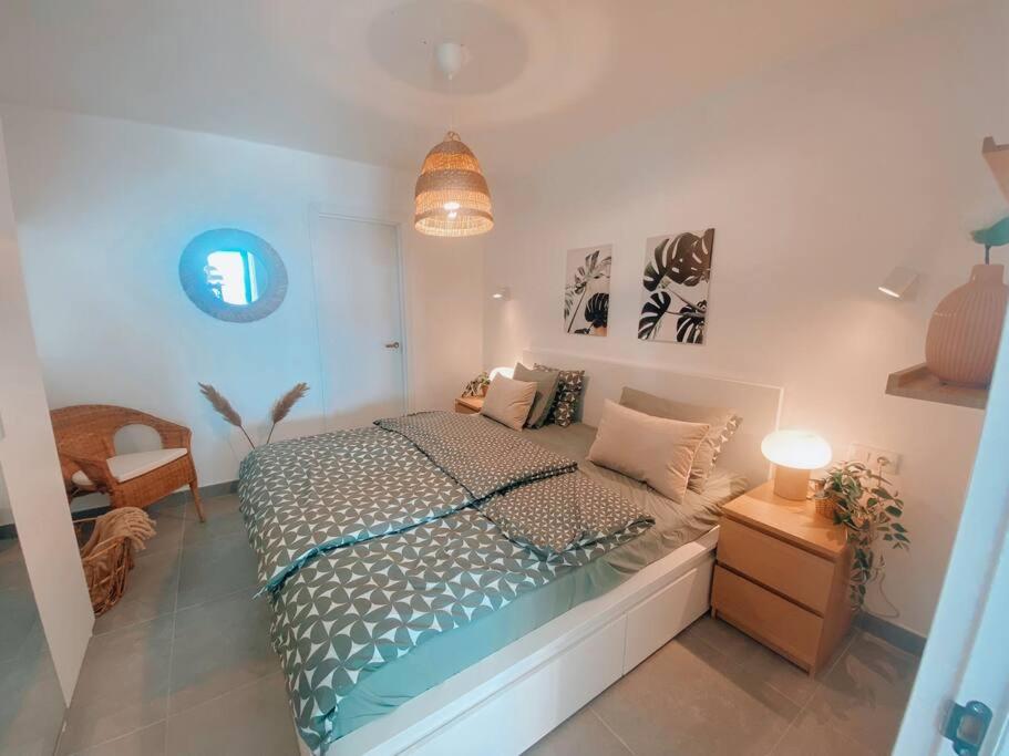 a bedroom with a large bed and a lamp at Casa Rosalía II in Puerto del Carmen in Tías