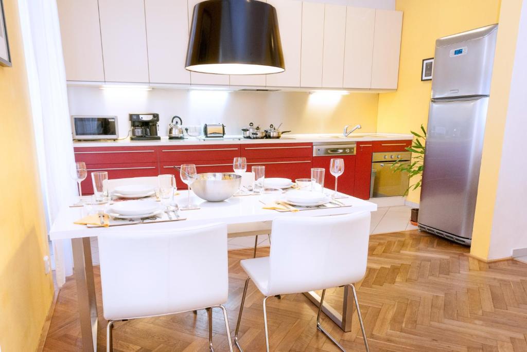 eine Küche mit einem weißen Tisch und weißen Stühlen in der Unterkunft Modern Apartment - Prague Centre in Prag