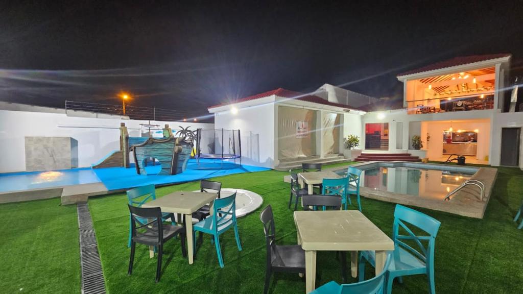 ein Haus mit einem Pool, Tischen und Stühlen in der Unterkunft Hotel Villa Del Mar in Salinas