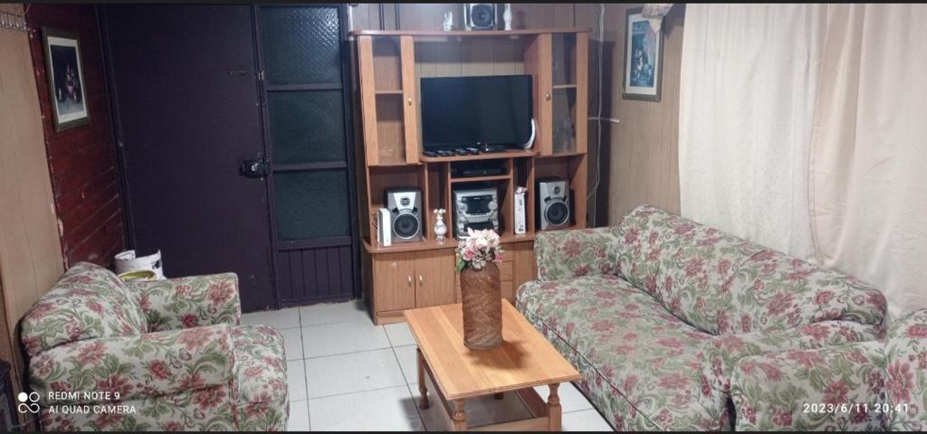 uma sala de estar com dois sofás e uma televisão em CASA ISLA MOTA em Valdivia