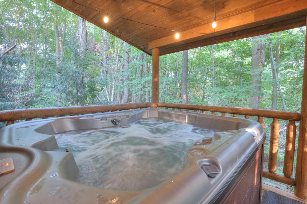 a jacuzzi tub in a cabin in the woods at Grapevine Cabin by Amish Country Lodging in Millersburg