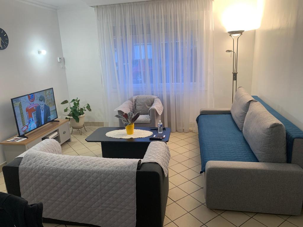 a living room with two couches and a table at Maison 4 à 8 personnes in Faches-Thumesnil