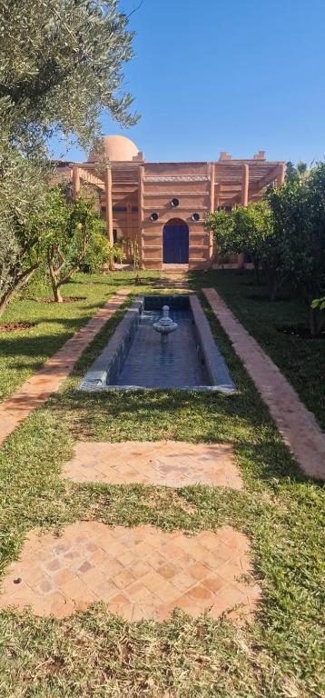 een huis met een vijver voor een gebouw bij VILLA ROSERAIE in Marrakesh