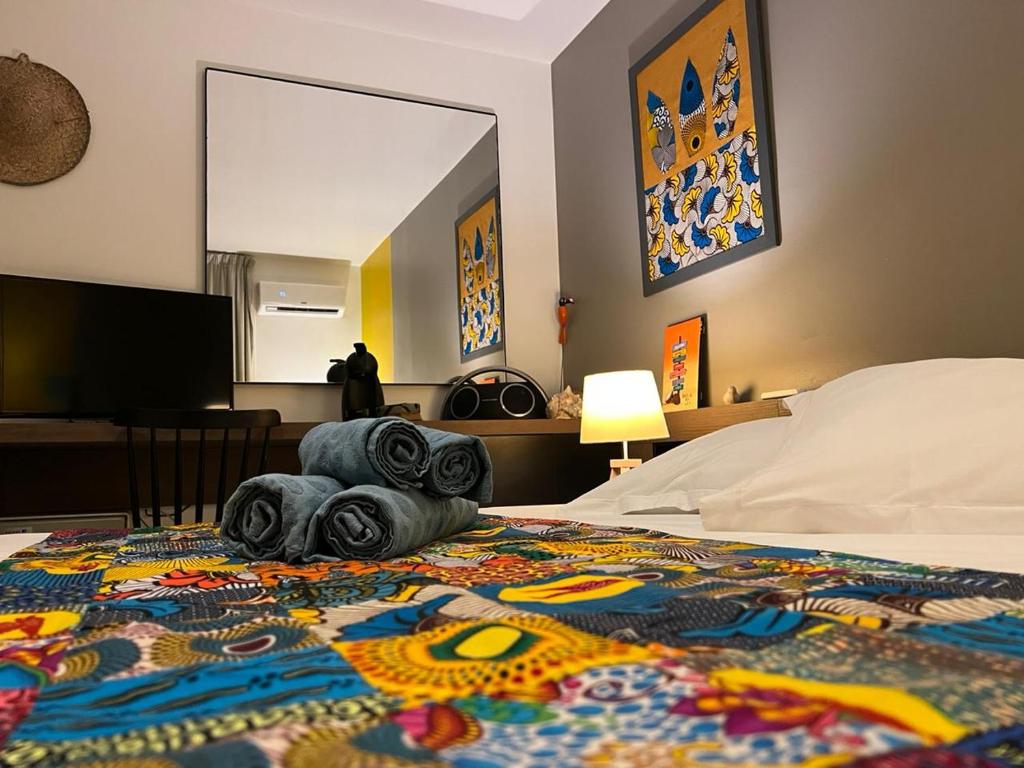 a hotel room with a bed with a colorful blanket at Plaisir Caraïbes in Belle-Allée