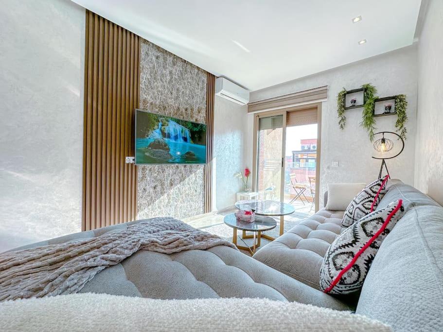 - une chambre avec un lit et une télévision murale dans l'établissement New apartement next carre eden, à Marrakech
