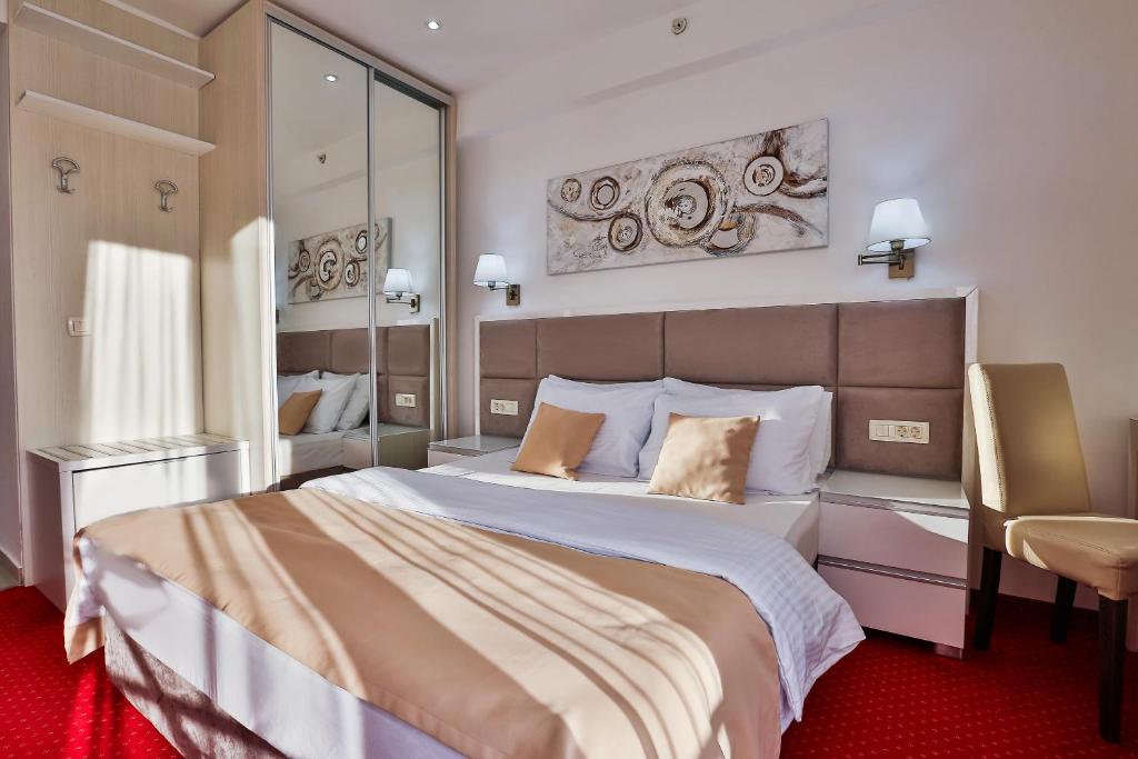 a bedroom with a large bed and a chair at Hotel La mer in Budva