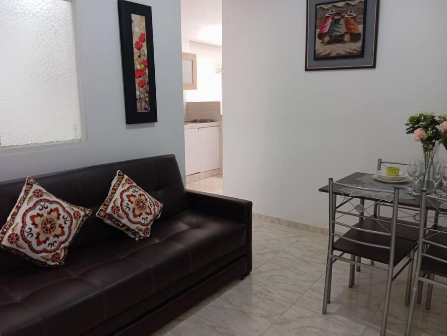 a living room with a black couch and a table at Apartamento central en Cali, Colombia 302 in Cali