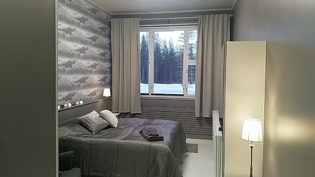 a bedroom with a bed in front of a window at GuestHouse Ikimetsä in Kuusamo