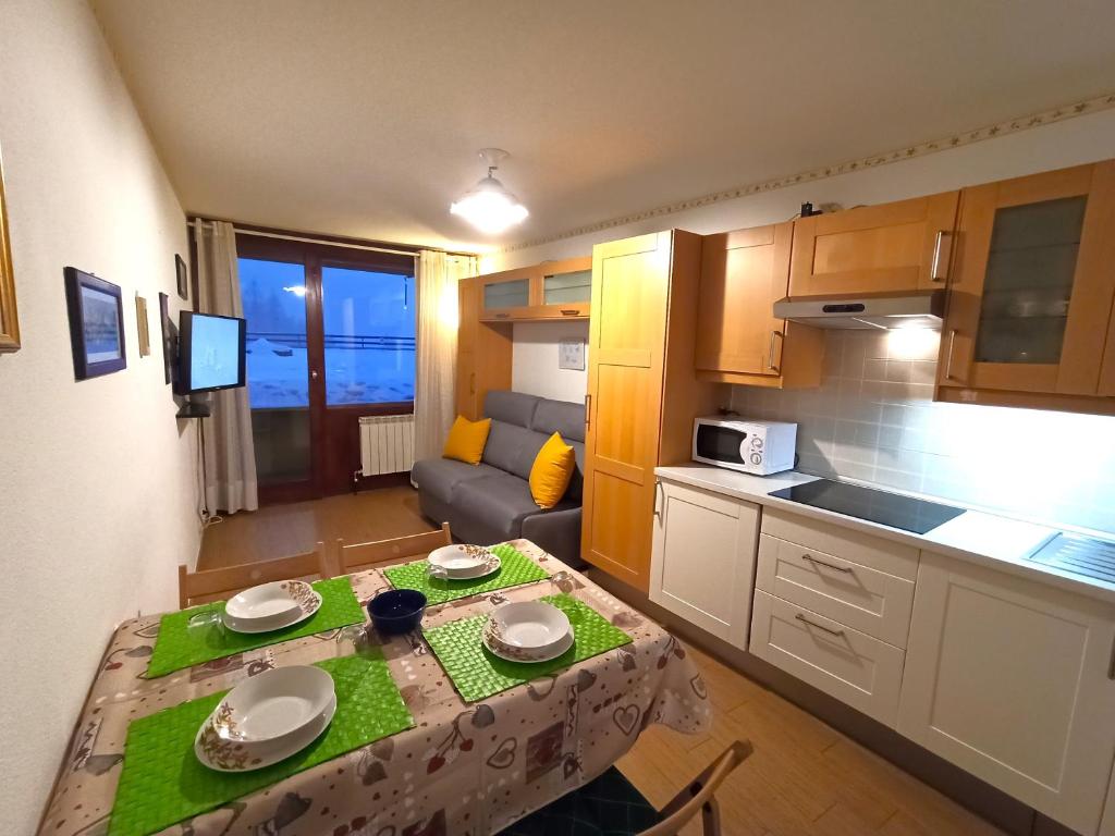 ブレウイル・チェルヴィナイアにあるFagus Cervinia apartment Vda Vacanze in Vetta CIR 0206の小さなアパートメントで、小さなキッチン(テーブル付)が備わります。
