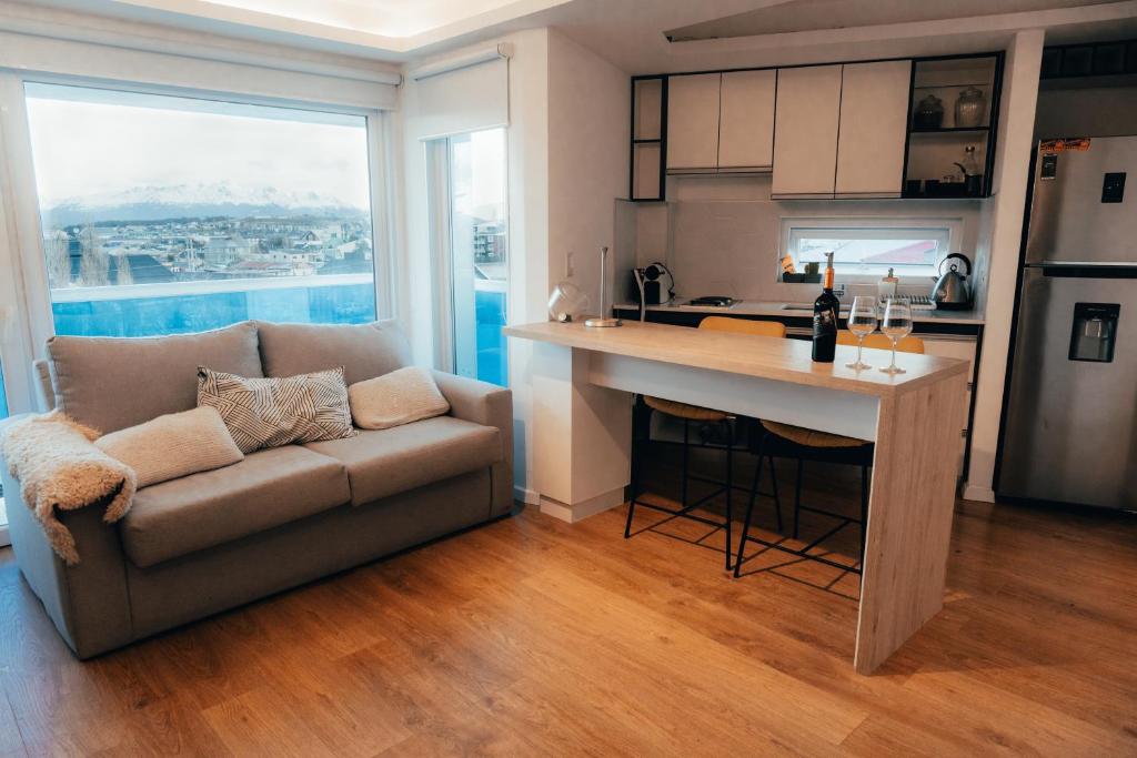 een keuken en een woonkamer met een bank en een tafel bij Depto Marinas - Full Rent in Ushuaia