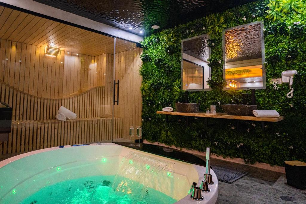 baño con bañera con plantas verdes en Le Nature - Sauna - Balnéo - Sparoom Sarreguemines en Sarreguemines