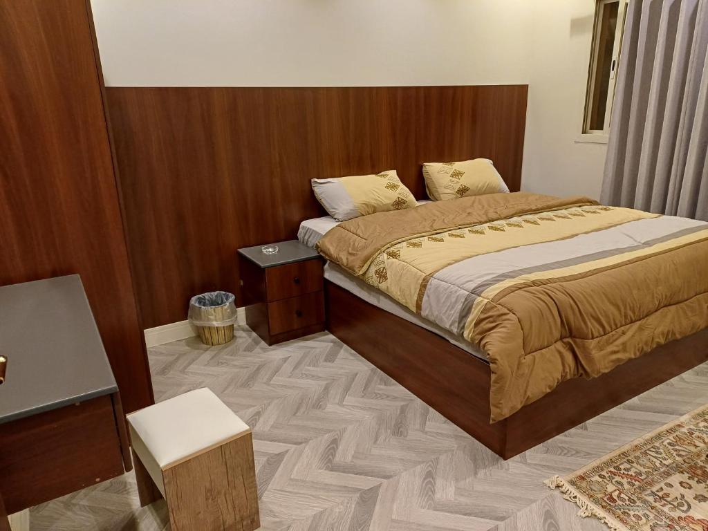 ein Schlafzimmer mit einem Bett und einer Holzwand in der Unterkunft شقه فندقيه غرفه وصاله دخول ذاتى in Riad