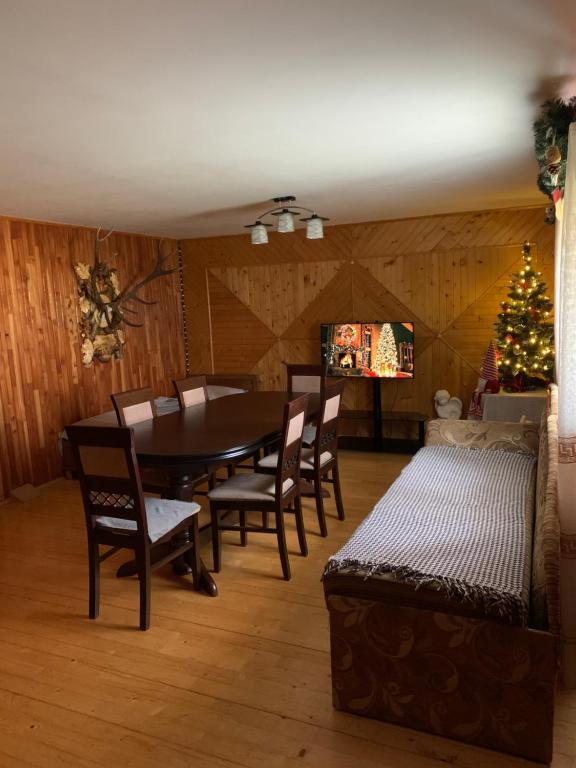 a dining room with a table and chairs and a christmas tree at Під Боржавою in Volovets