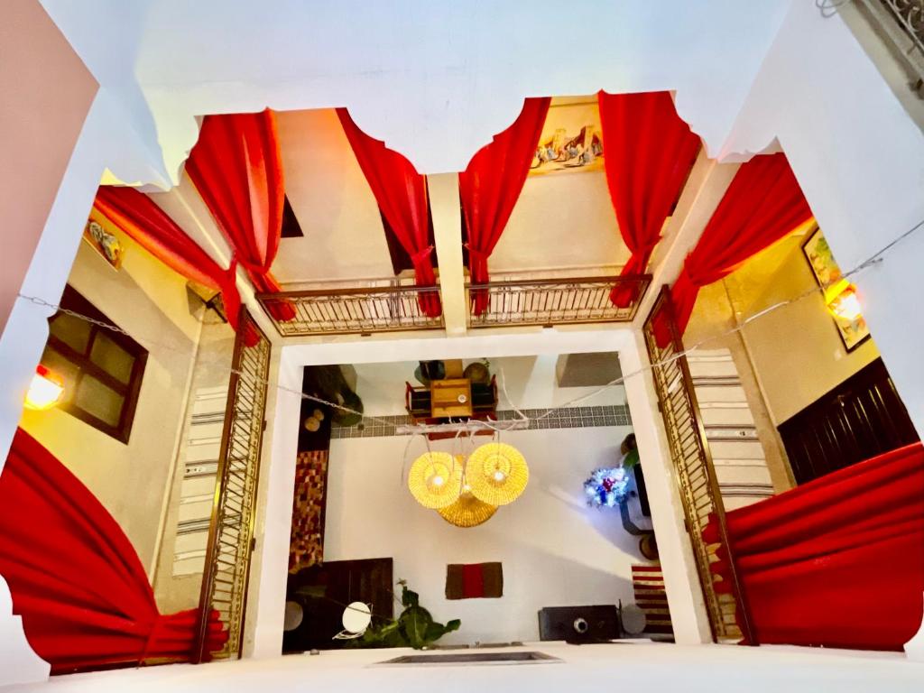 um quarto com cortinas vermelhas e um espelho em Riad Al Wafaa em Marrakech