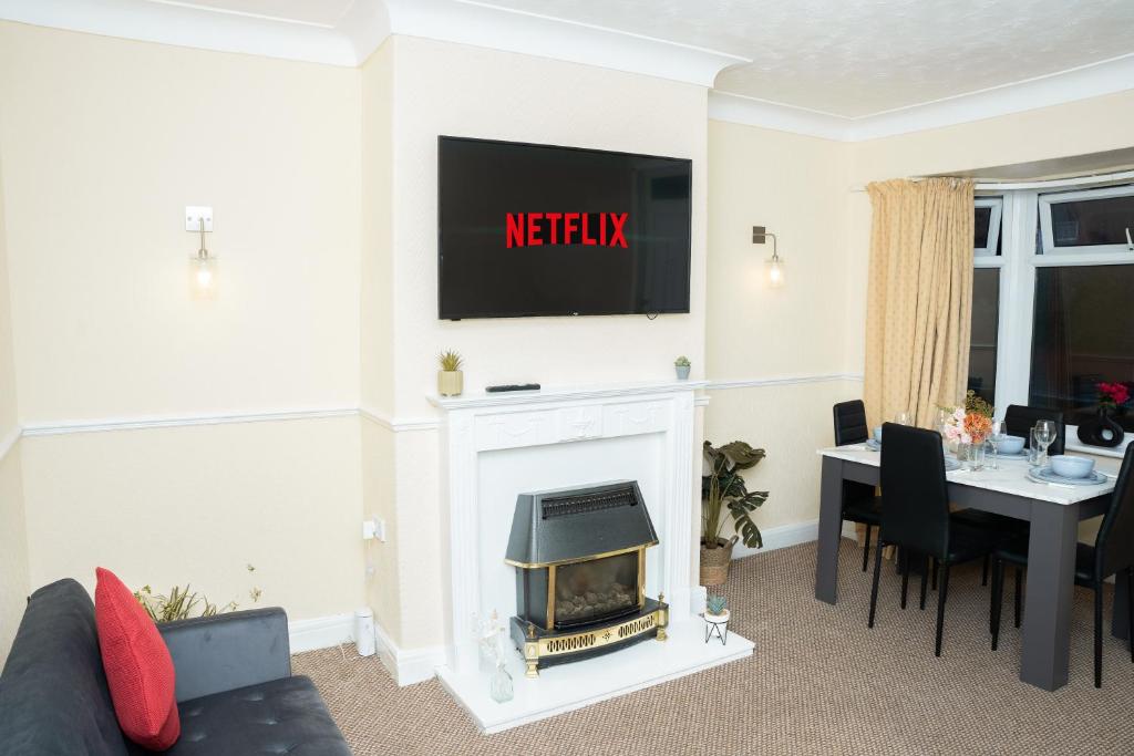 a living room with a fireplace with a tv above it at Modern Retreat Central Location Close to The City in Killingbeck