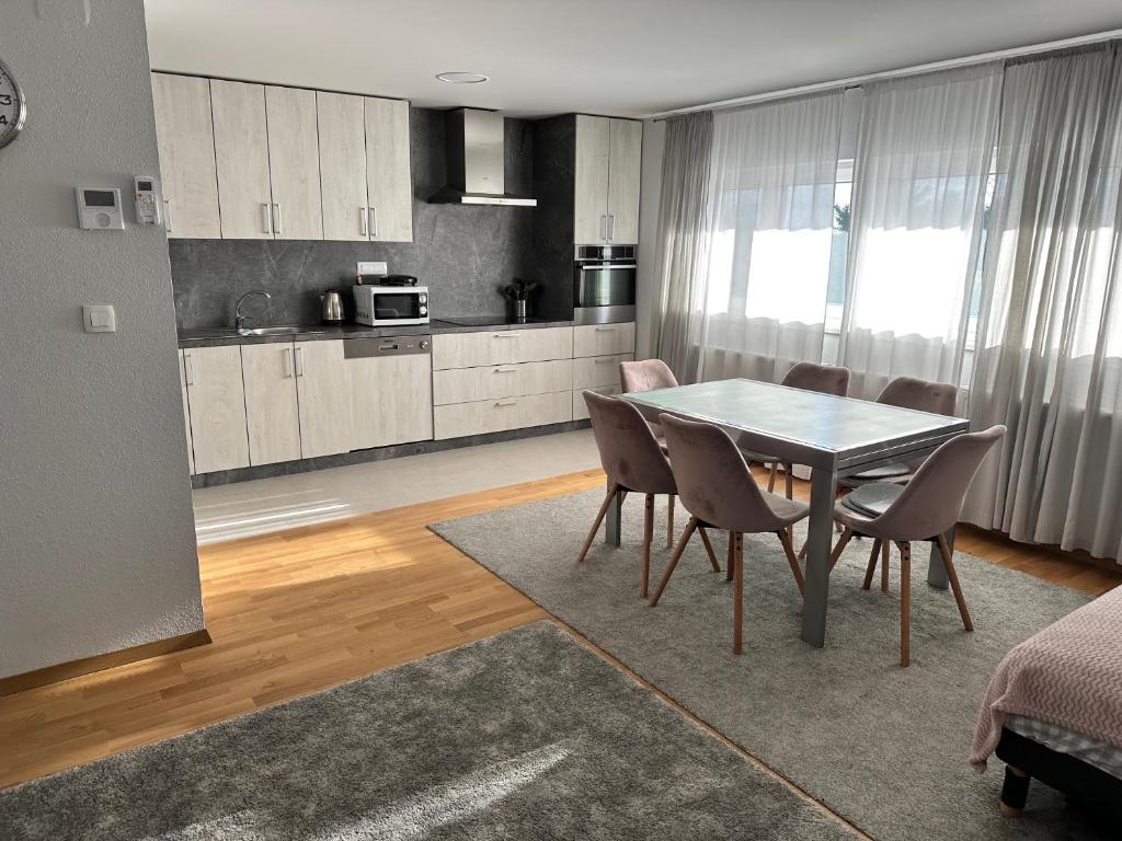 uma cozinha e sala de jantar com mesa e cadeiras em Apartman PEPI em Zagreb