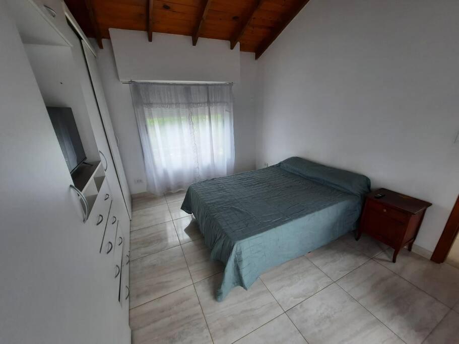 um quarto com uma cama e uma televisão em Necochea-Casa para hasta 4 personas! em Necochea