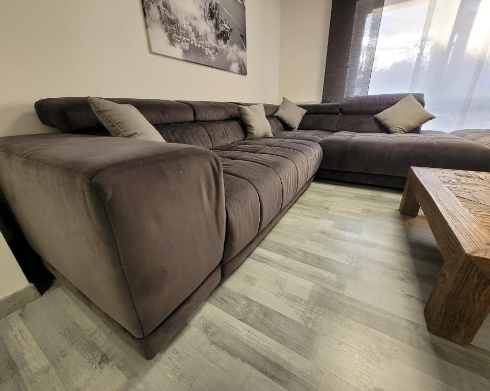 sala de estar con sofá marrón y mesa en Le Cinéphile : Vivez comme une star à Hollywood !, en Creutzwald-la-Croix
