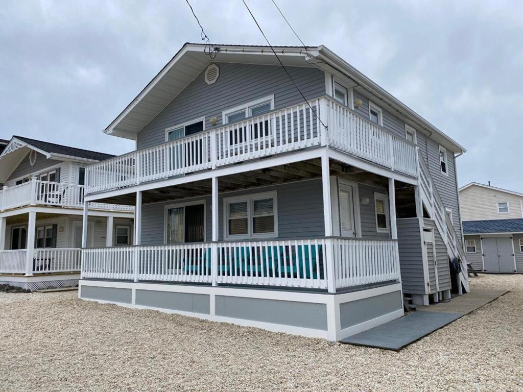 ein großes Haus mit weißer Ausstattung am Strand in der Unterkunft Newly Renovated Ocean Block Duplex Located In The Heart Of Surf City, in Surf City