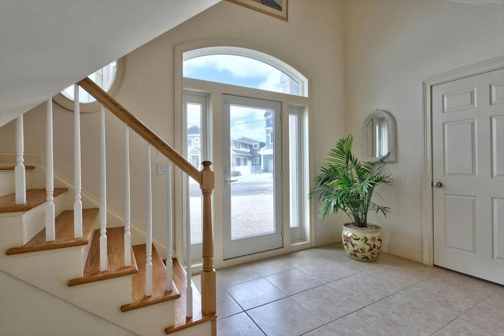 een hal met een trap en een deur met een plant bij Spectacular Views Surf City Ocean Front With 6 Bedrooms, Great Beach!! in Surf City