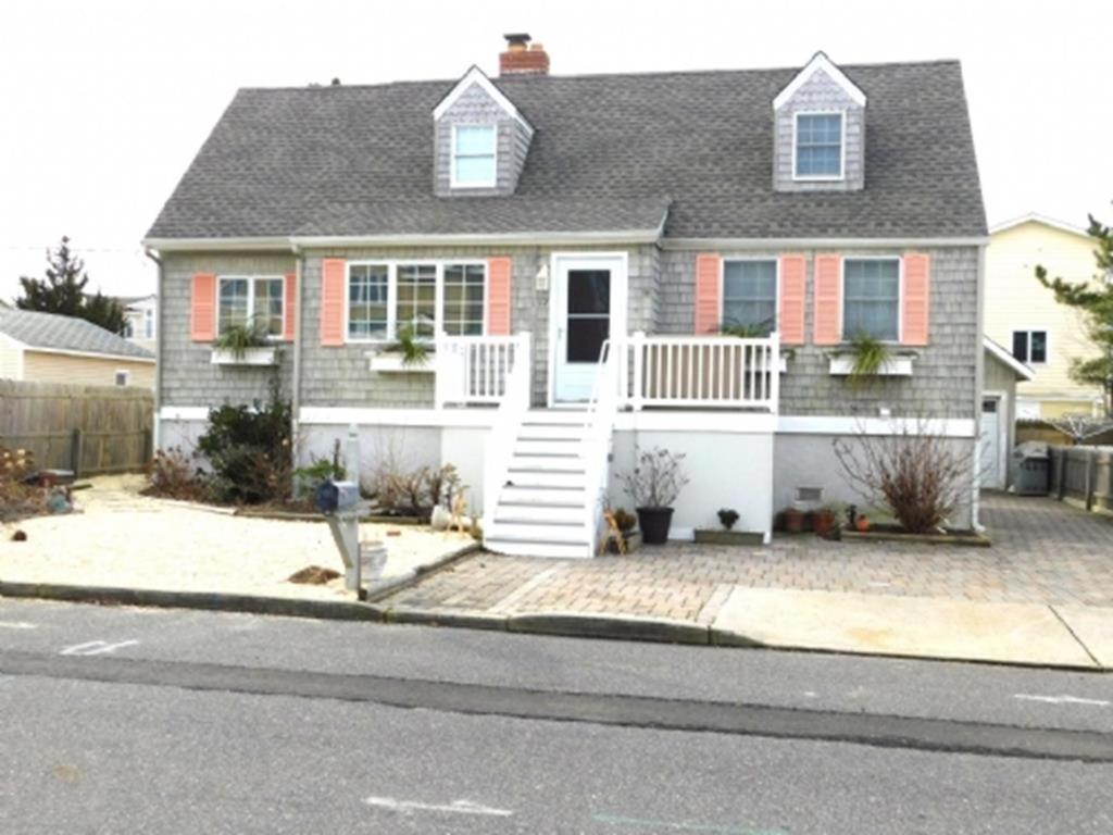 una casa con porche blanco y aphalt en Lovely Cape 5 Homes To The Beach, en Brant Beach