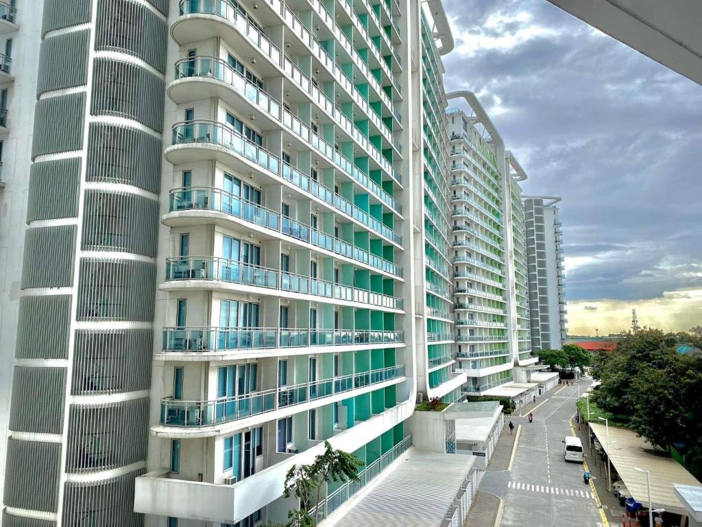 a tall apartment building with balconies on a street at Azure Condo in Manila