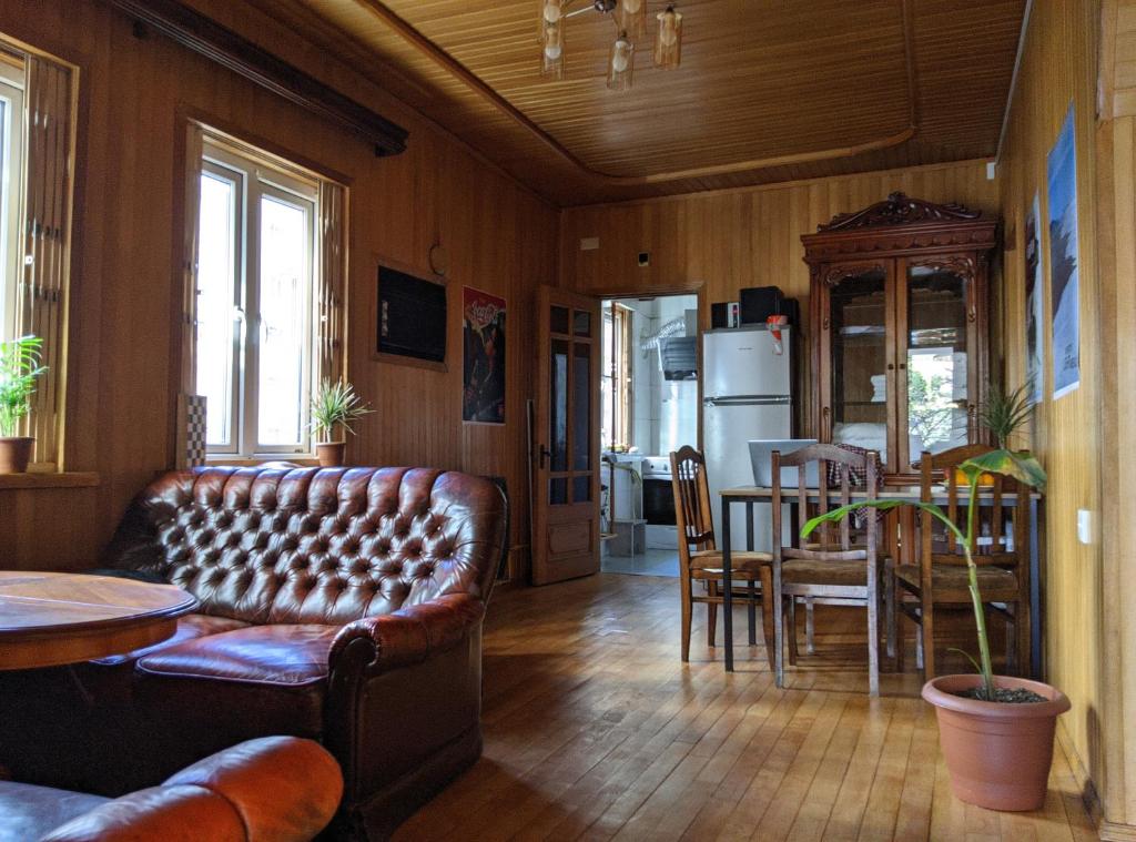 a living room with a leather couch and a table at Palm Hostel in Batumi