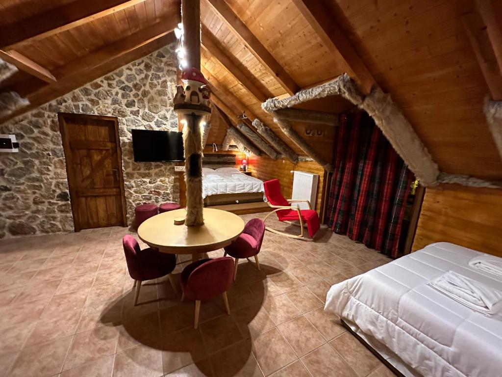1 dormitorio con 1 cama, mesa y sillas en Ο Σκίουρος Παραδοσιακοί Ξενώνες en Oíti
