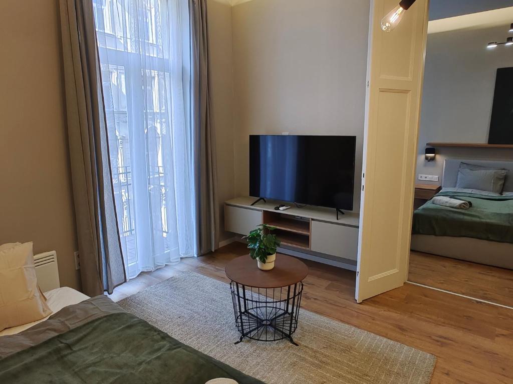ein Wohnzimmer mit einem Flachbild-TV und einem Tisch in der Unterkunft CITY CENTER 2, Cozy and Modern 2br in the city center in Budapest
