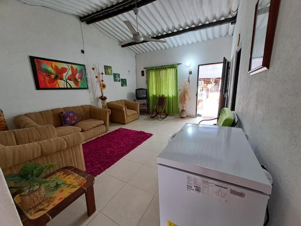 un soggiorno con divano e frigorifero di Casa La Pajarita a Santa Marta