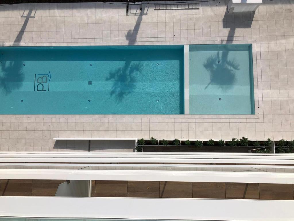 a swimming pool with a bench in front of it at Palm beach appartment 80 mt dal mare e comodo per Venezia in Lido di Jesolo