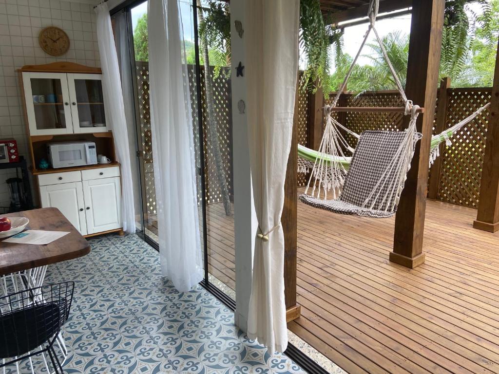 a porch with a hammock on a wooden deck at Residencial Jurerê Belo in Florianópolis