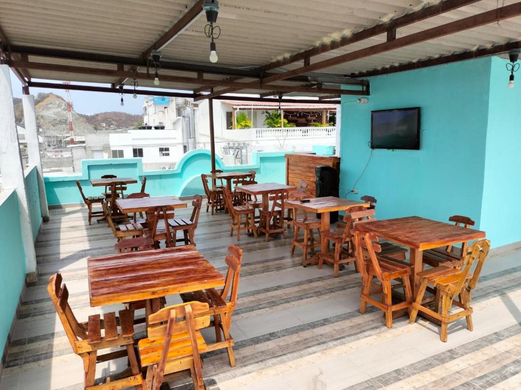 un restaurante con mesas de madera y sillas en una terraza en Hotel Las Vegas by Marbar Hoteles, en Santa Marta