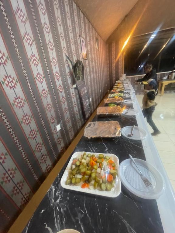 a long table with plates of food on it at Wadi Rum stargazing camp in Wadi Rum