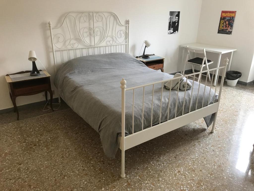 ein Schlafzimmer mit einem weißen Bett und zwei Nachttischen in der Unterkunft Villa Fiorelli rooms in Rom