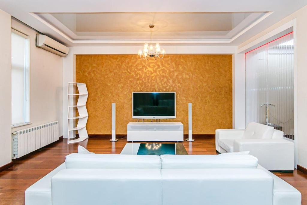 a living room with white furniture and a flat screen tv at Vip Apartment Zanzibar in Baku